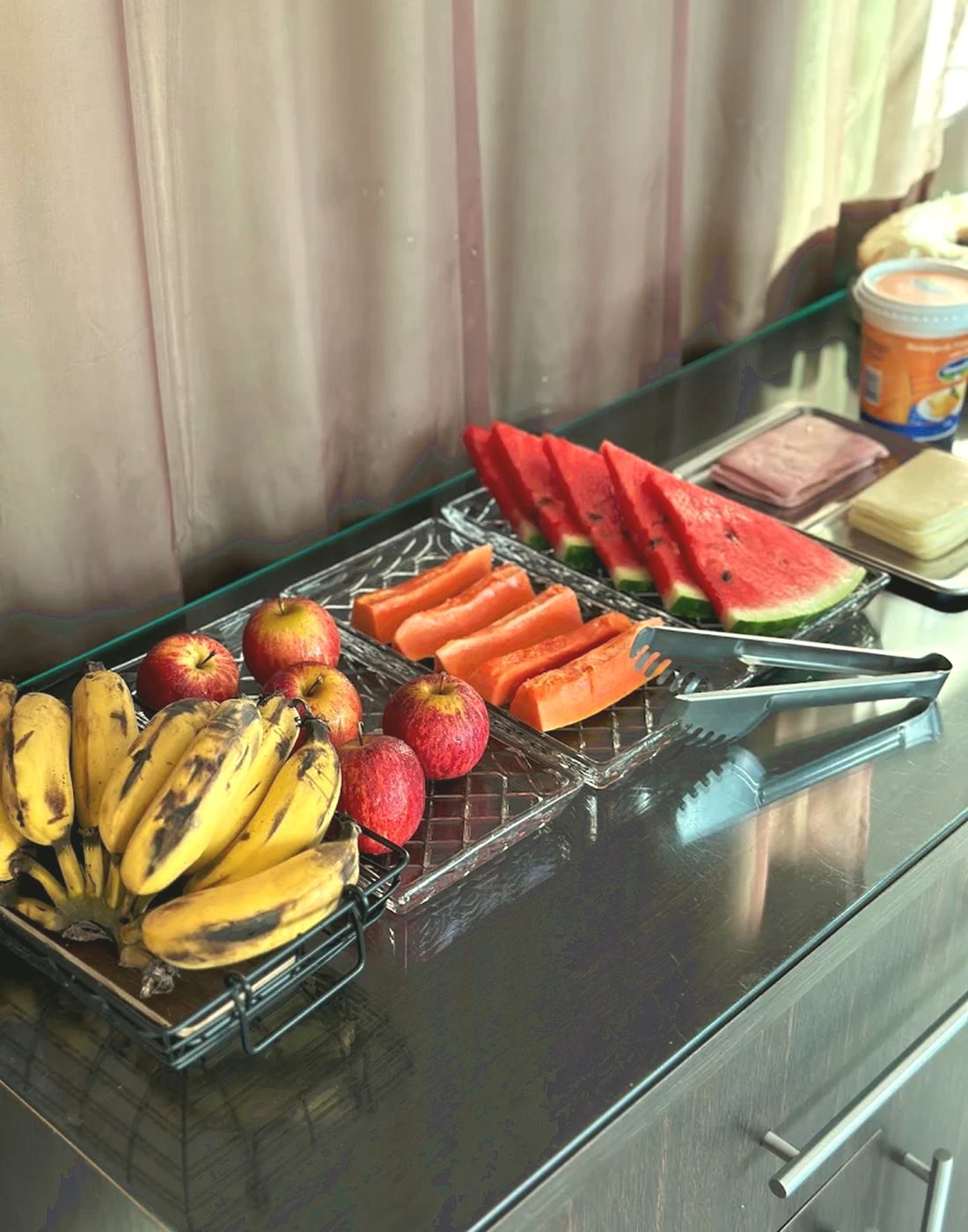 Mesa do café da manhã com frutas cortadas, sucos e bolo