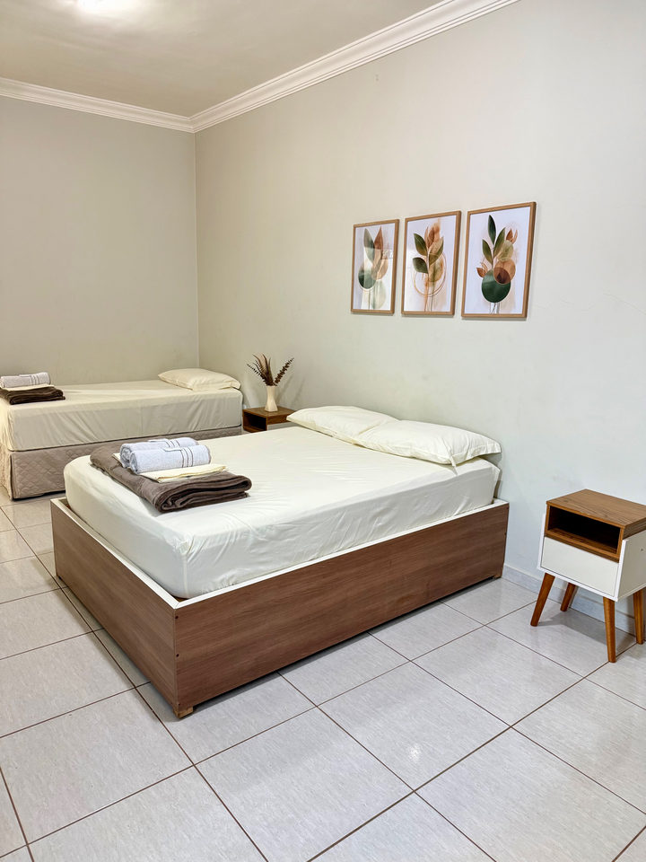 Cama de casal e cama de solteiro no mesmo apartamento, com dois quadros