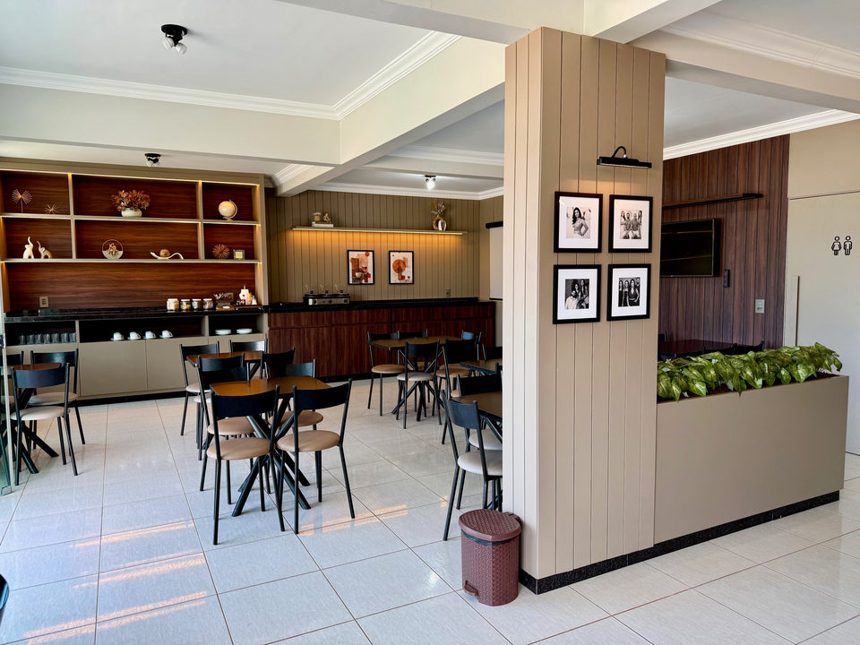 Salão do café da manhã visto da entrada, com a coluna de quadros