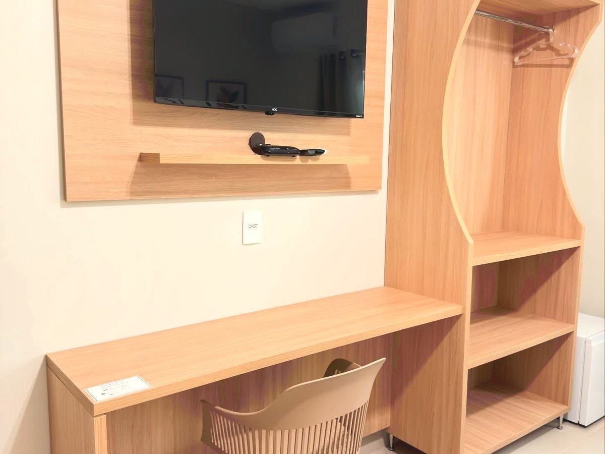 Escrivaninha com cadeira e televisão no apartamento